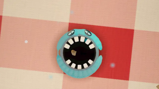 A teal monster mouth gulping food on a picnic blanket